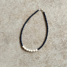 Load image into Gallery viewer, Pearl and seed bead necklace in navy on a  beige background

