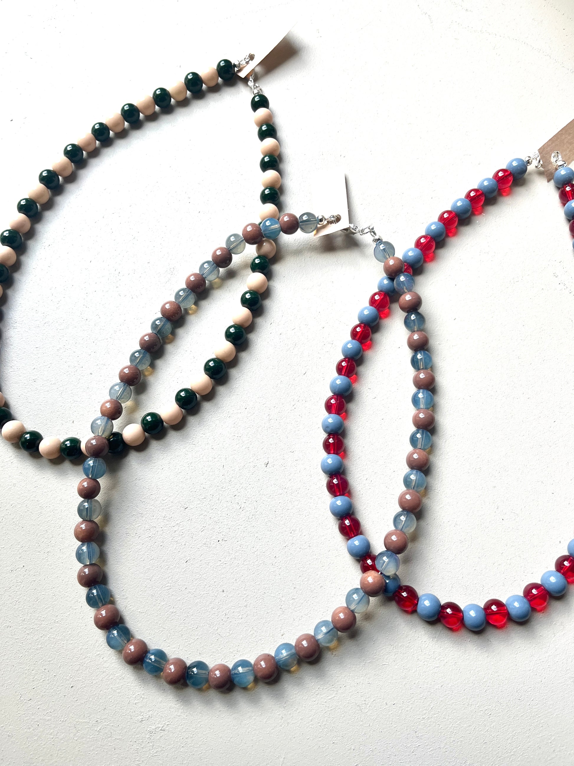 Three glass beaded necklaces on a white background