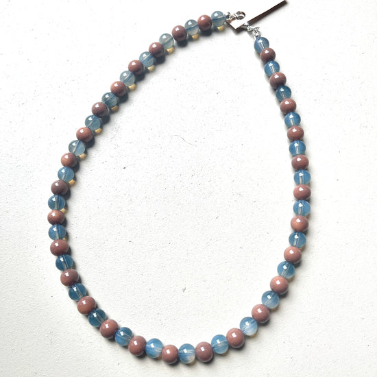 Necklace with blue and mauve beads on a white background