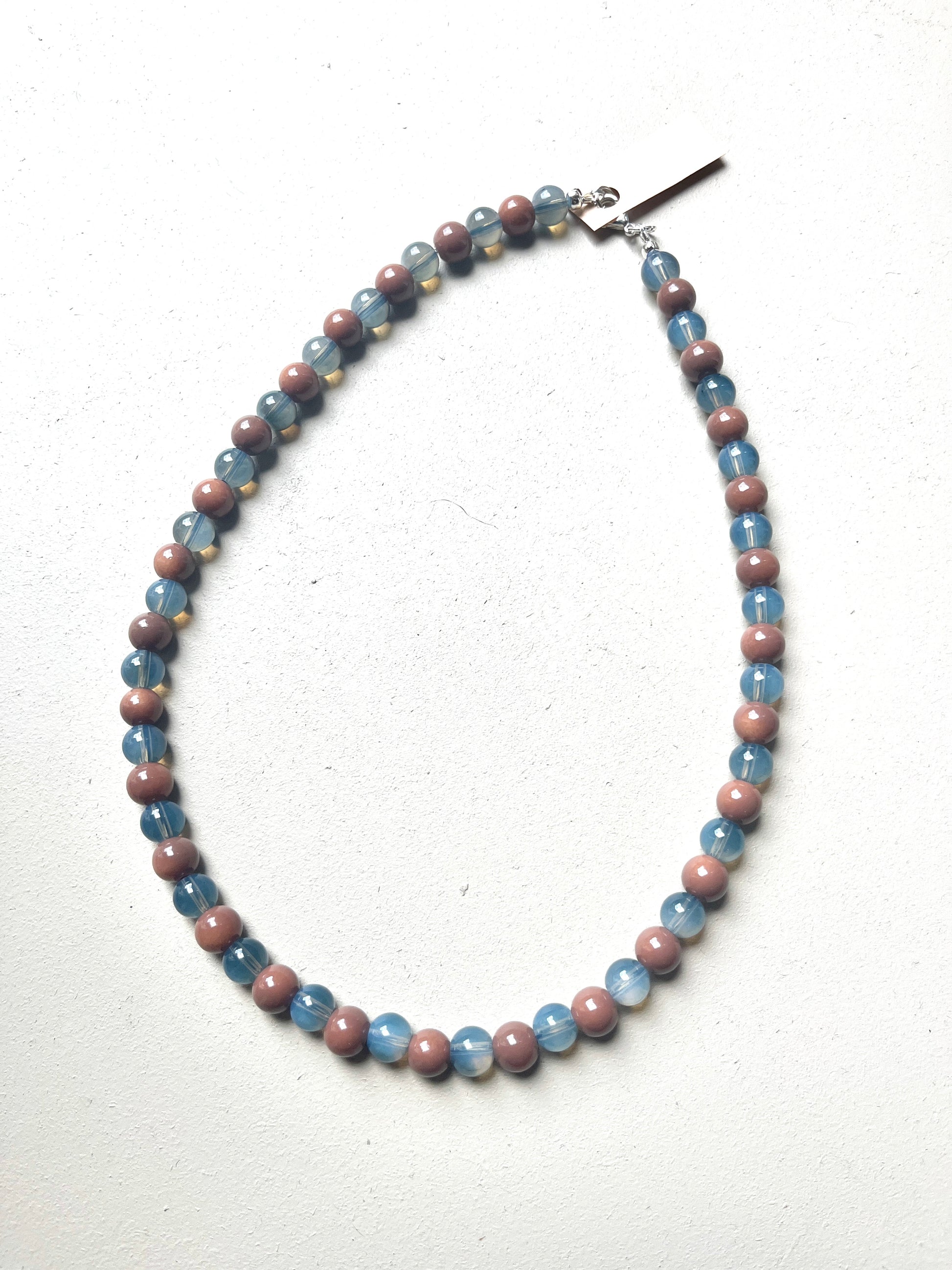 Necklace with blue and mauve beads on a white background
