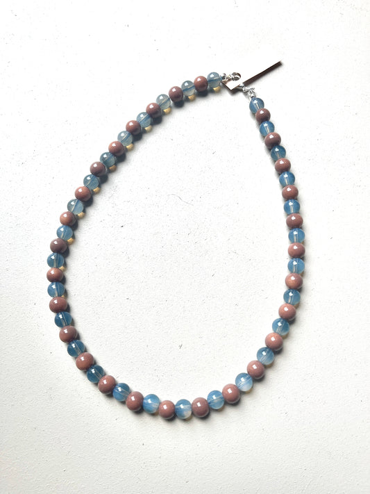 Necklace with blue and mauve beads on a white background