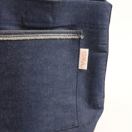 Dark blue denim bag with a visible brand label on a white background