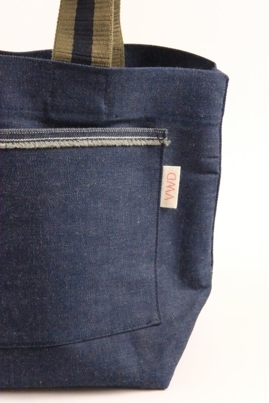 Dark blue denim bag with a visible brand label on a white background
