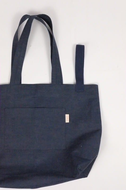 Navy blue tote bag with a pocket on a light gray background