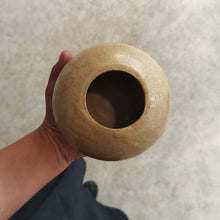 Load image into Gallery viewer, Hand holding a small brown ceramic pot against a neutral background
