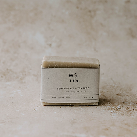 Bar of soap in a box labeled 'WS + Co' on a textured beige background