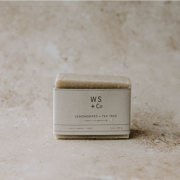 Bar of soap in a box labeled 'WS + Co' on a textured beige background
