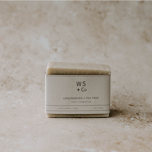 Bar of soap in a box labeled 'WS + Co' on a textured beige background