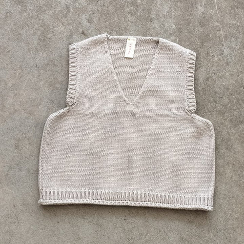 Knitted vest on a gray concrete surface