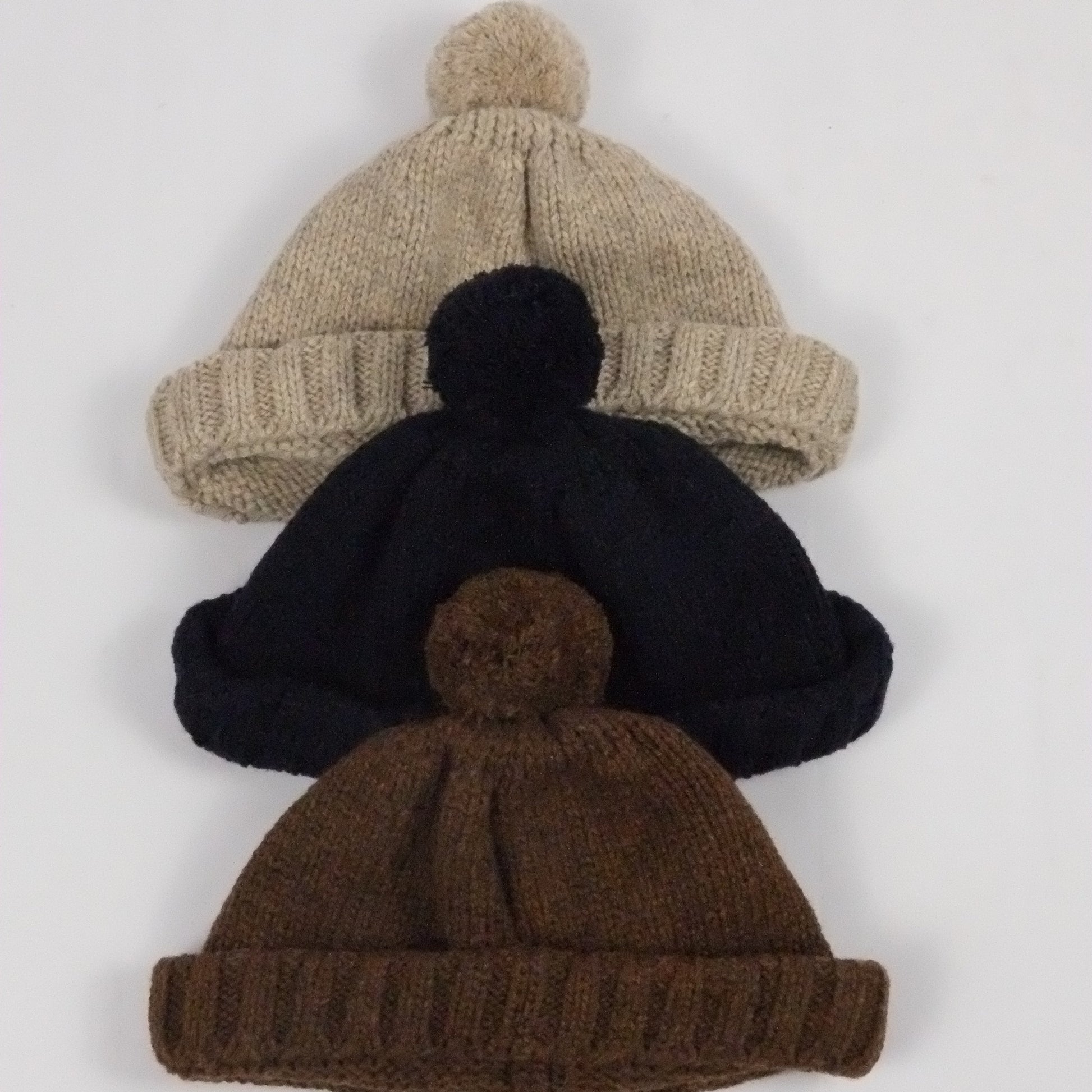 Three knit beanies in beige, black, and brown on a white background