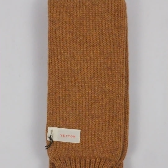 Brown knitted headband with a brand label on a light gray background