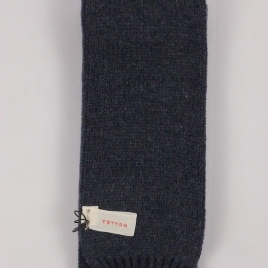 Dark gray knit scarf with a brand tag on a light gray background