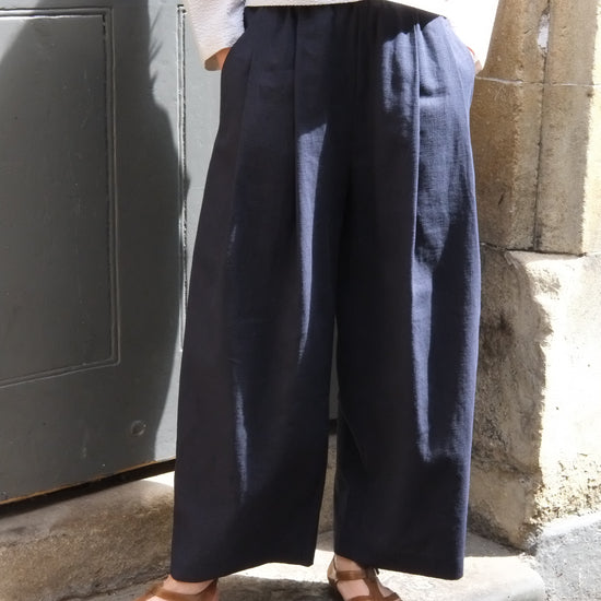 Person wearing navy pants and sandals standing on a step