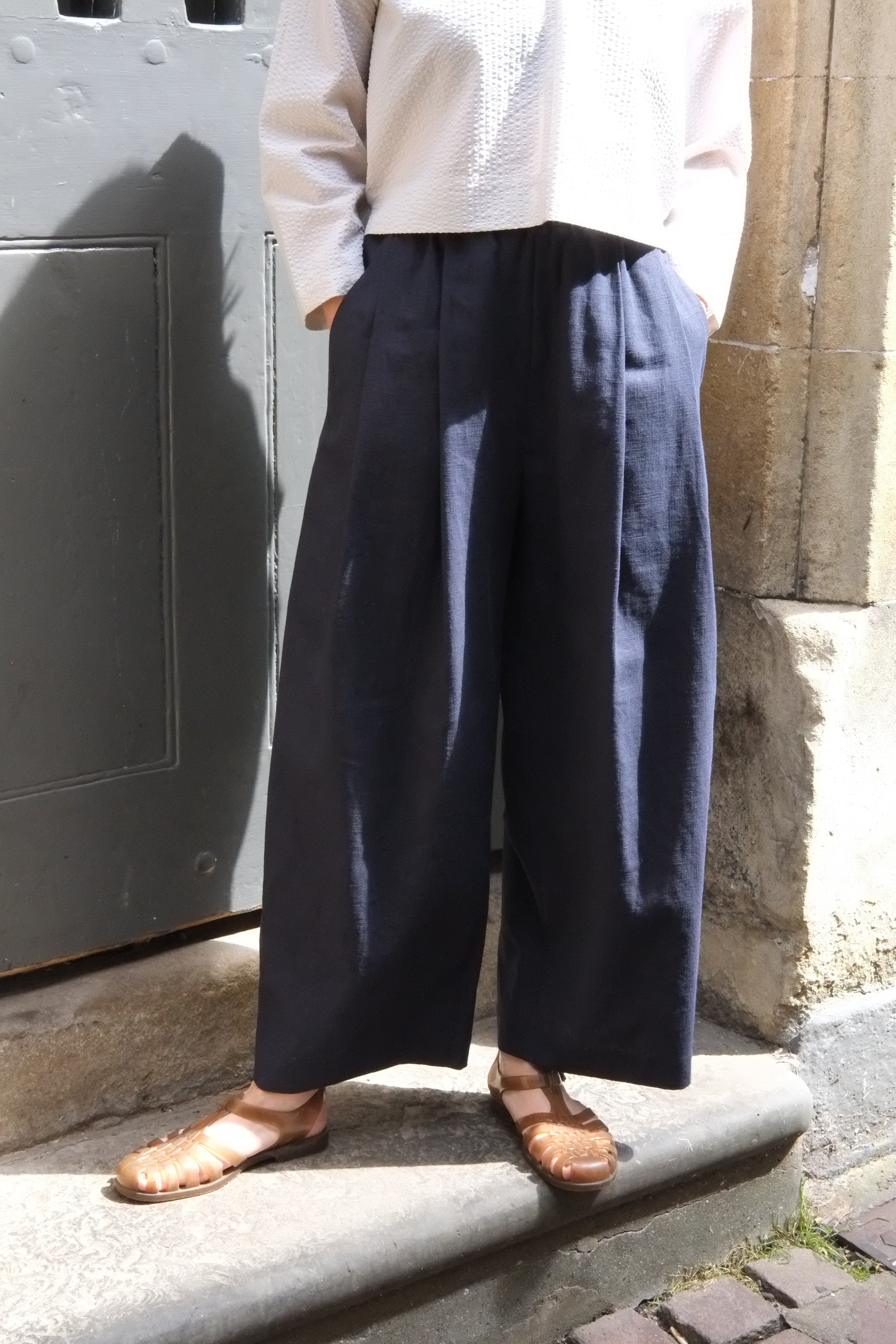 Person wearing navy pants and sandals standing on a step