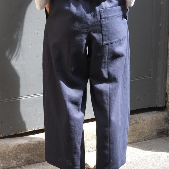 Person wearing dark pants and a light-colored shirt on a step.