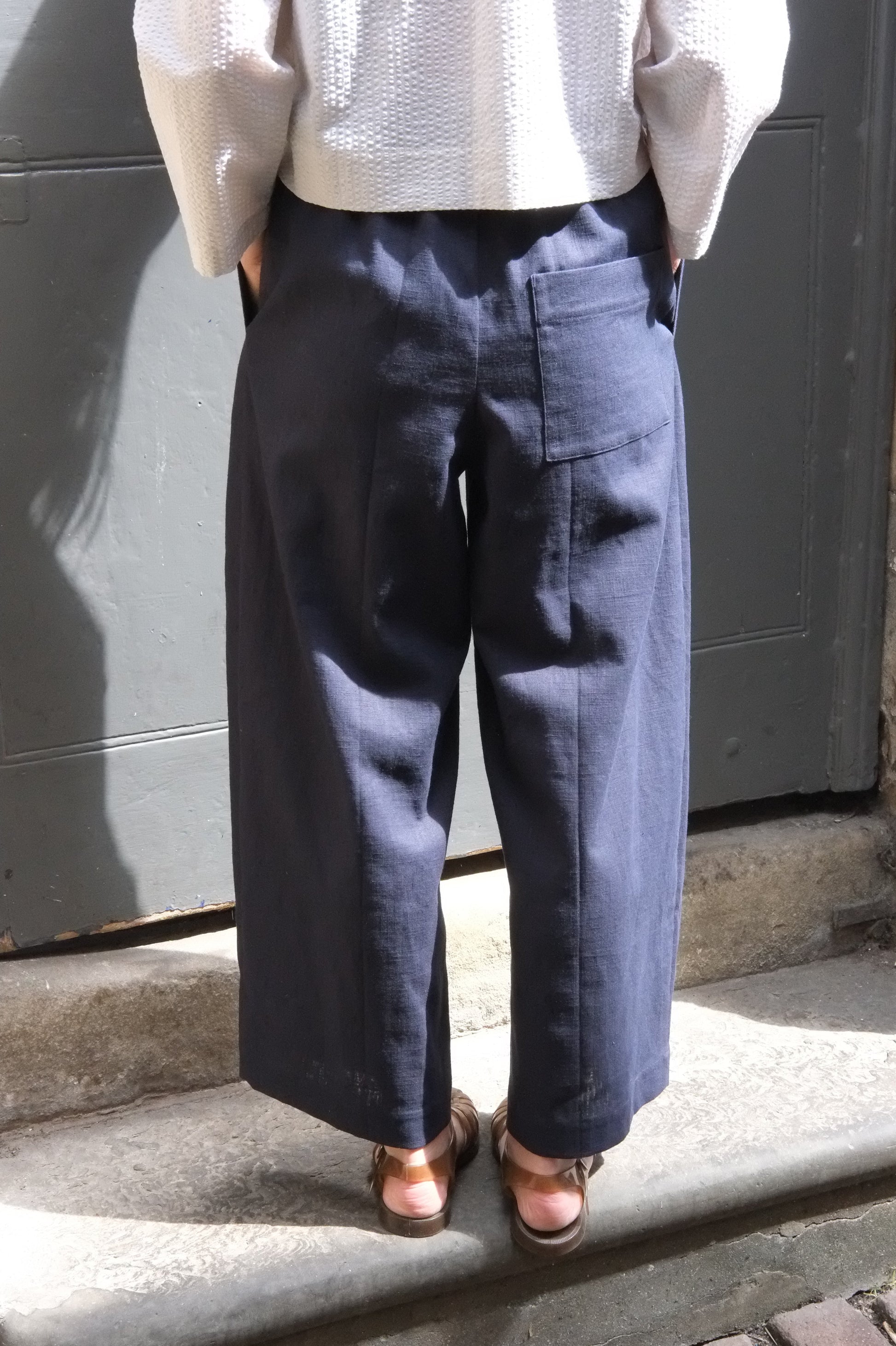 Person wearing dark pants and a light-colored shirt on a step.