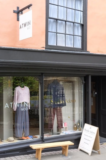Storefront with 'ATWIN' sign and clothing displayed in window