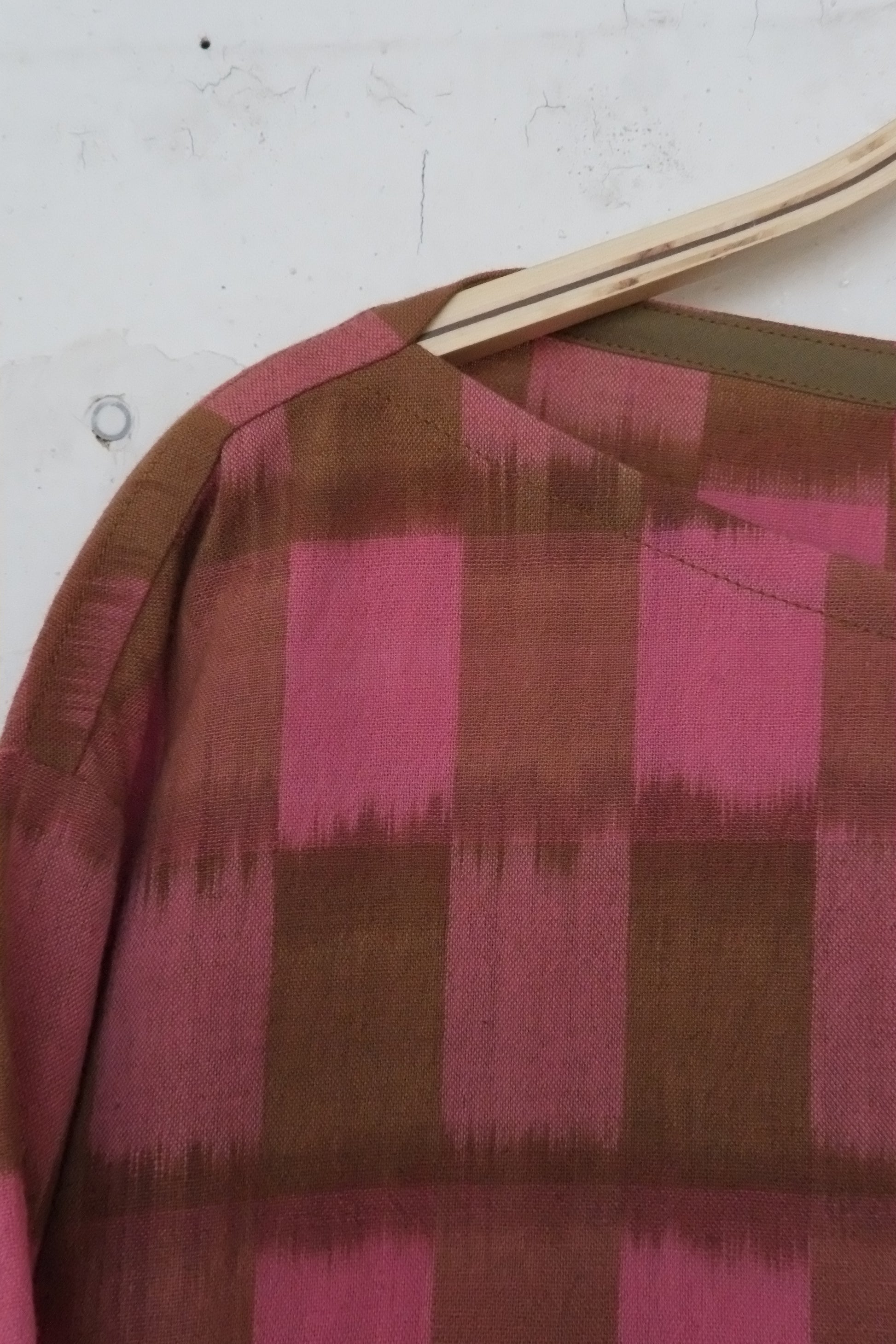 Close-up of a fabric with pink and brown checkered pattern on a white background