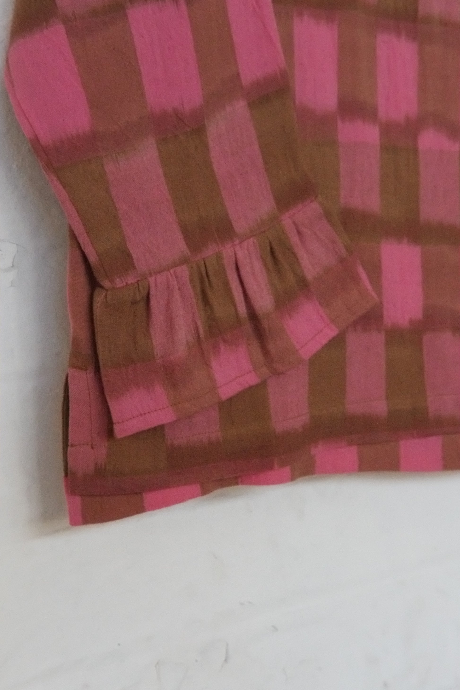 frilly fabric with pink and brown checkered pattern on a white background