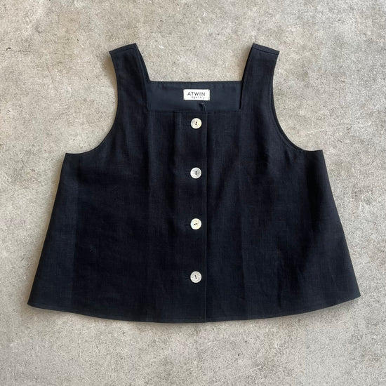Black sleeveless top with shell button details