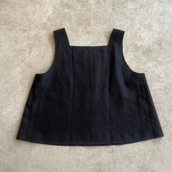 Black sleeveless top on a light gray surface