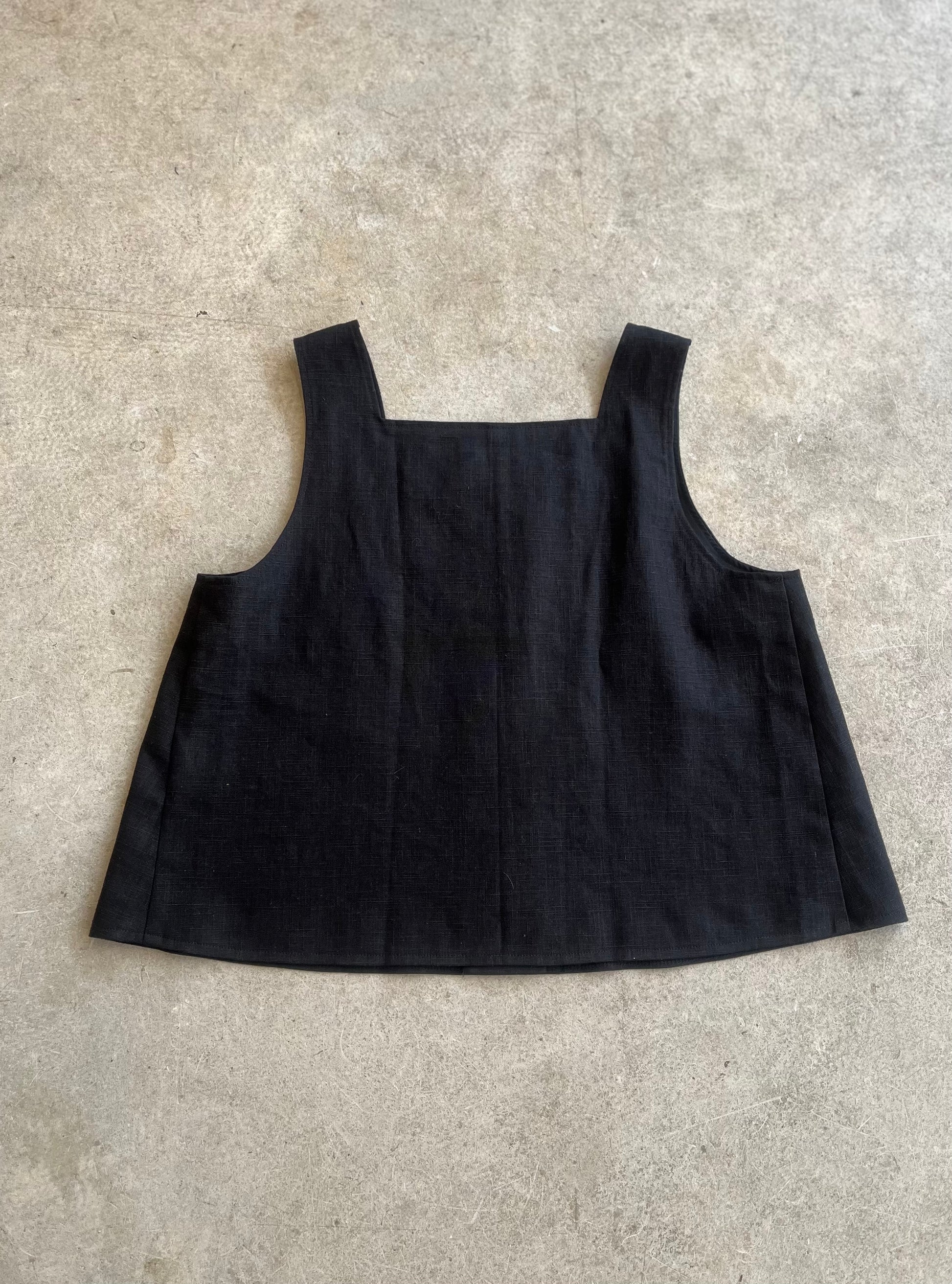 Black sleeveless top on a light gray surface