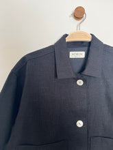 Load image into Gallery viewer, black workwear jacket with &#39;ATWIN&#39; label on a wooden hanger against a white background
