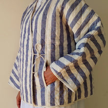 Load image into Gallery viewer, Person wearing a blue and white striped quilted jacket against a plain background

