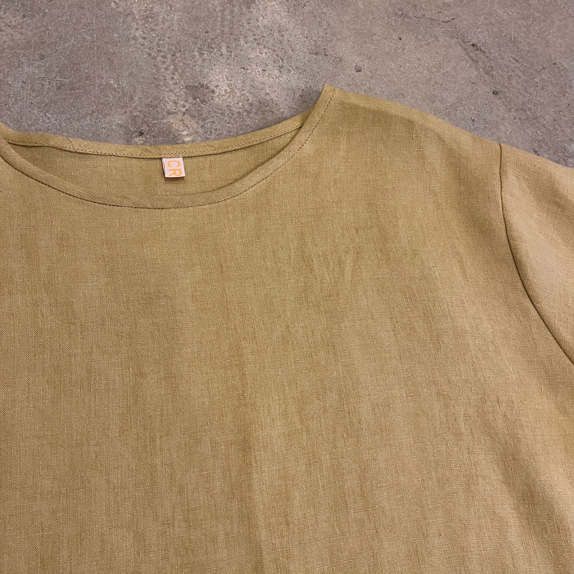 A yellow top on a dark beige backgrond 
