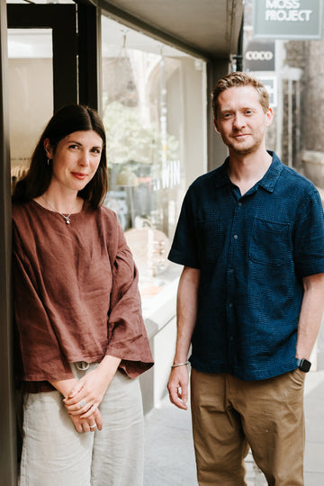 Two people standing outside a building with a glass door.
