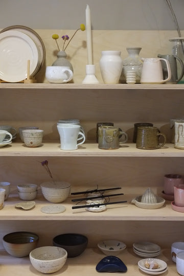Collection of ceramic and glass items in a wooden drawer