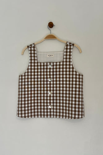 Brown and white checkered tank top on a hanger against a gray background