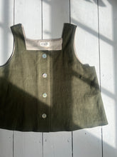 Load image into Gallery viewer, Green tank top with buttons on a white wooden background
