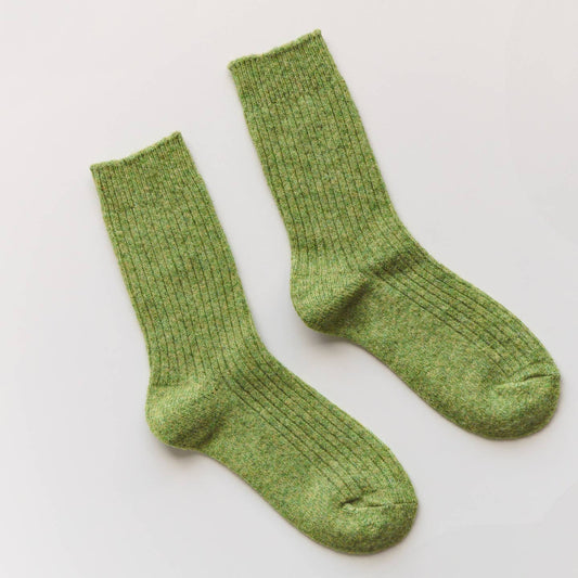 Pair of green socks on a light gray background