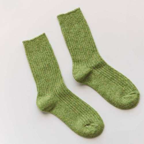 Pair of green socks on a light gray background