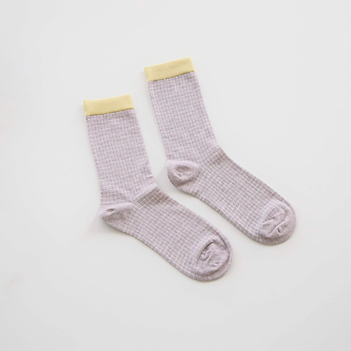 Pair of light purple checkered socks with yellow cuffs on a white background