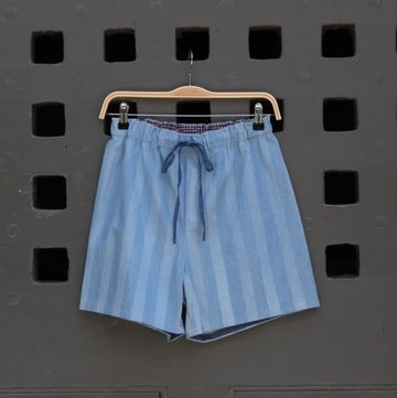 blue striped shorts hanging on a grey door