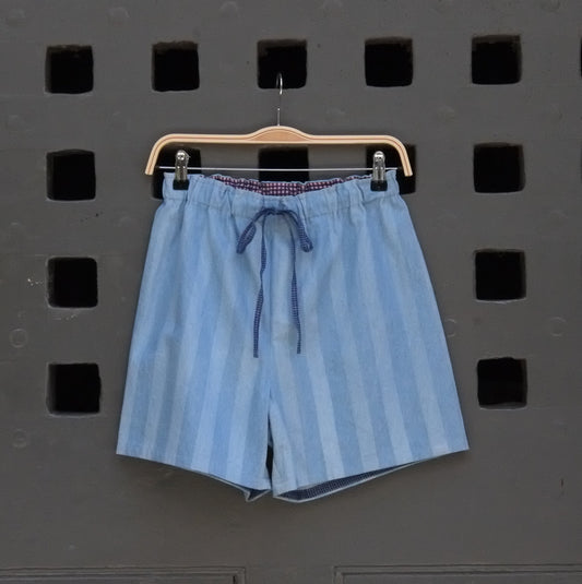 blue striped shorts hanging on a grey door