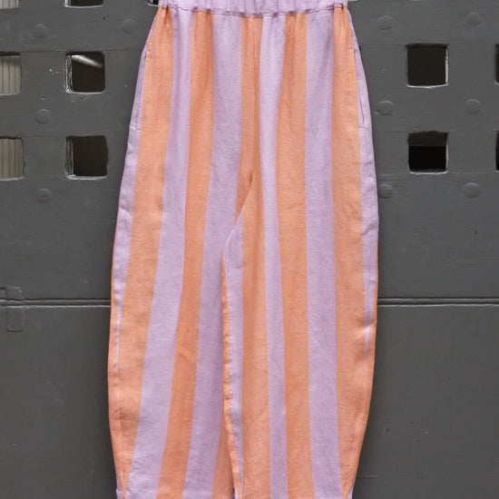 photo of some striped trousers hanging on a grey door 