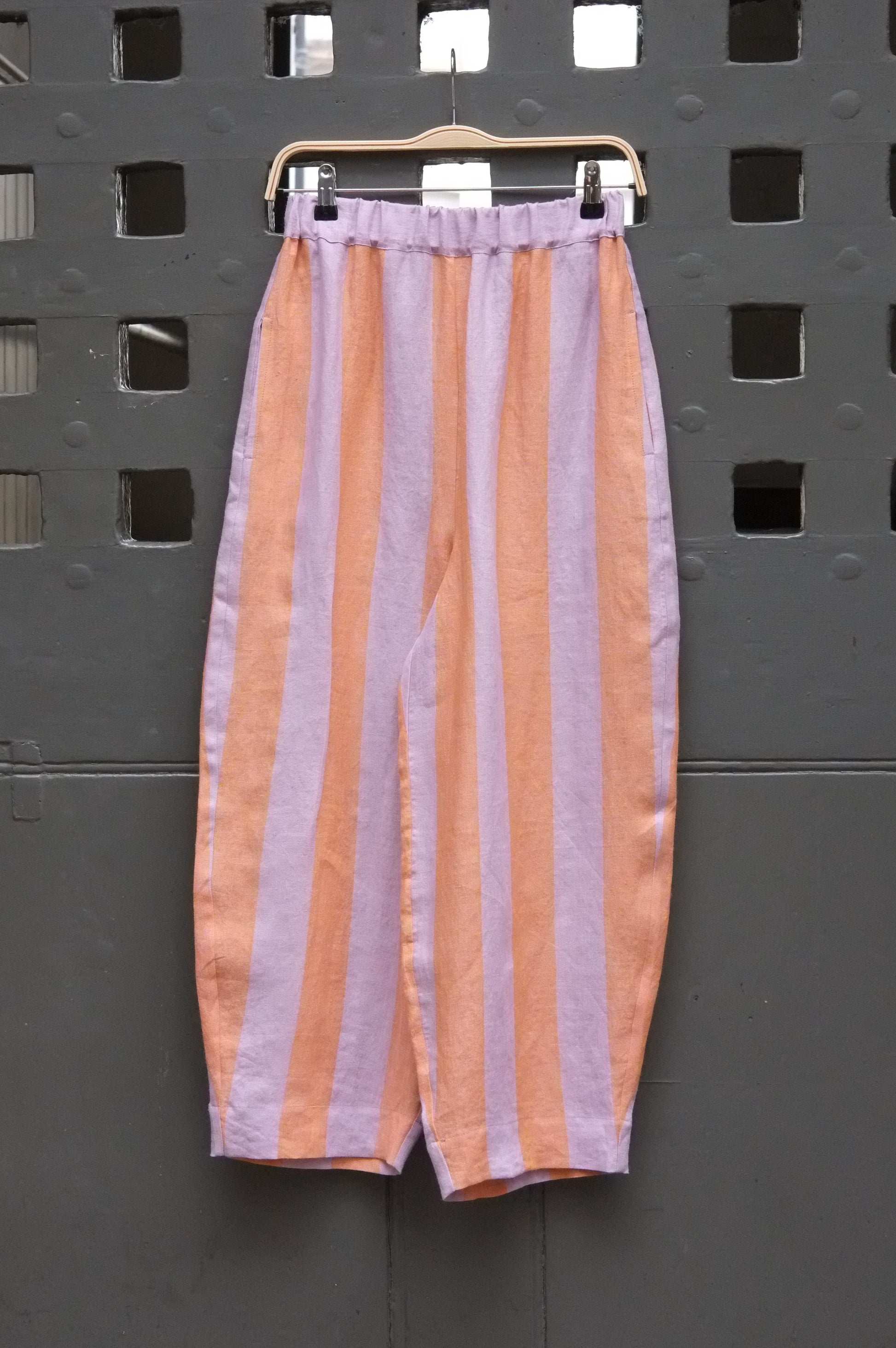 photo of some striped trousers hanging on a grey door 