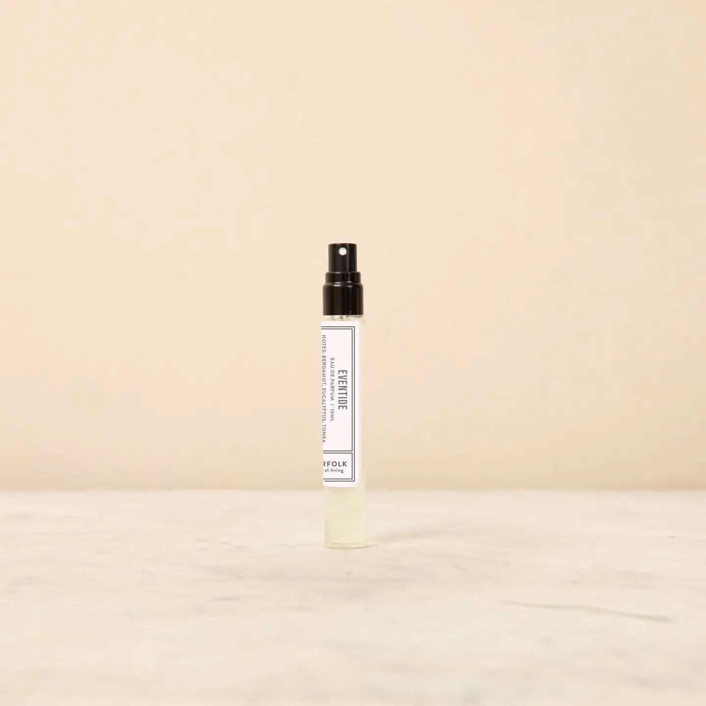 Small spray bottle with a white label on a beige background