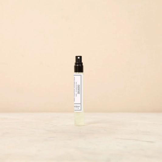 Small spray bottle with a white label on a beige background