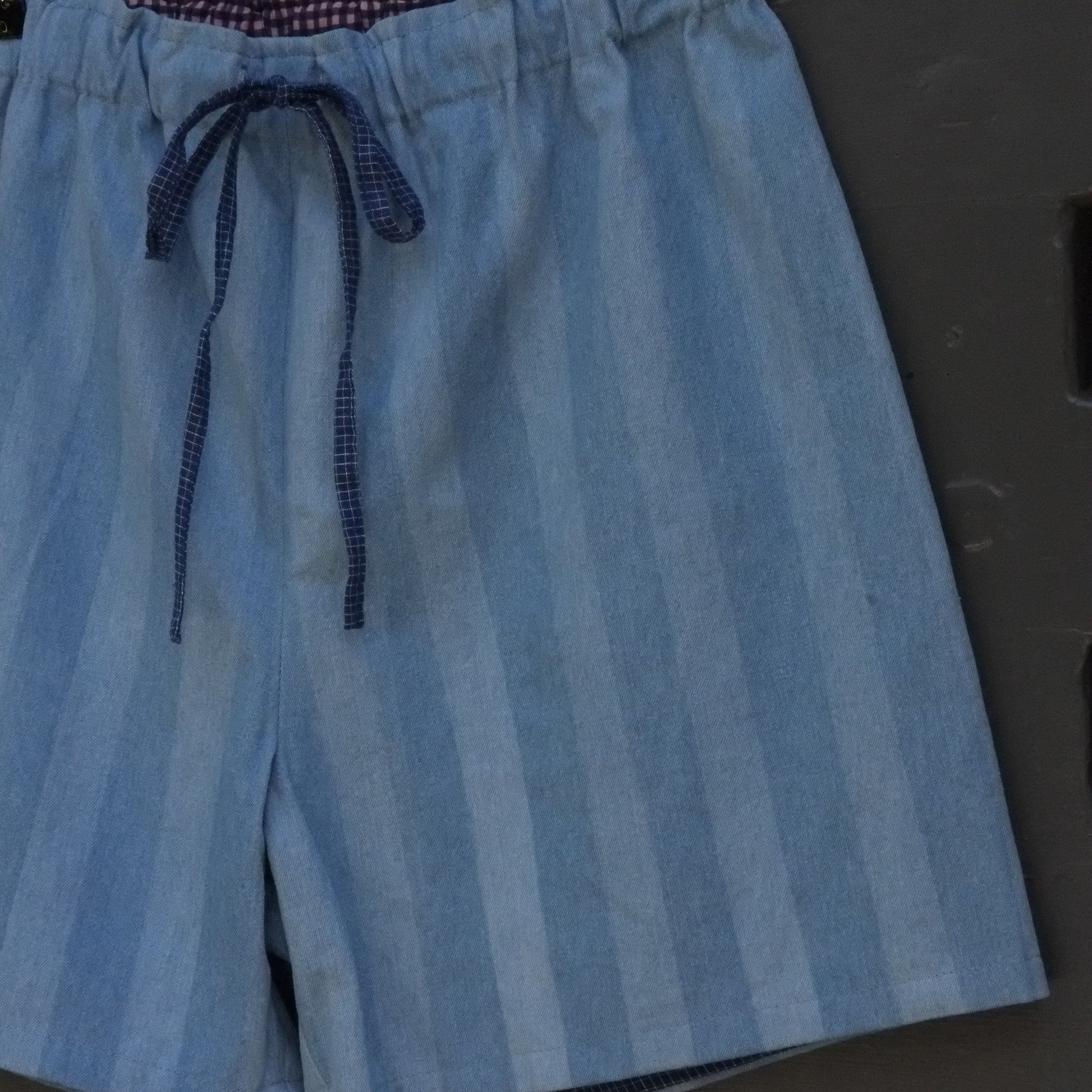 close up of blue striped shorts with navy drawstring