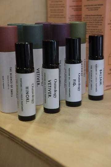 Collection of small cylindrical roll on perfume oils with labels on a wooden surface
