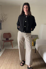 Load and play video in Gallery viewer, woman wearing a black linen workwear jacket and brown gingham trousers
