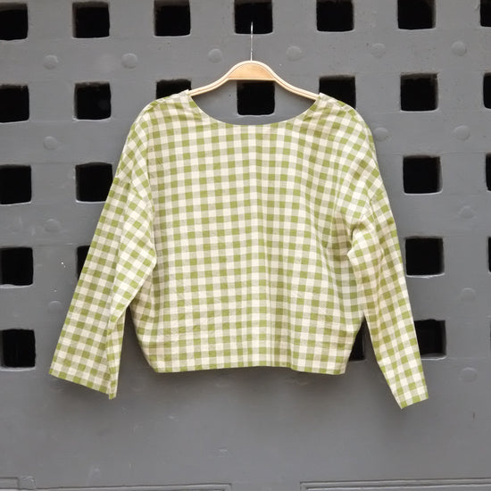Green checkered shirt on a grey door background