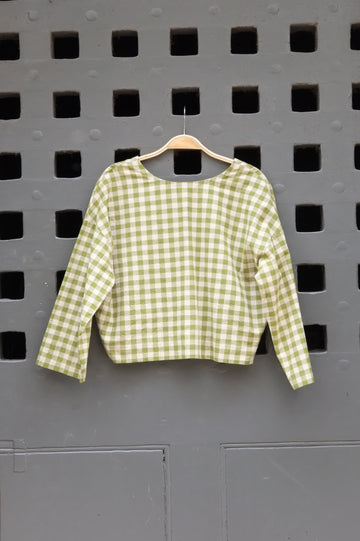 Green checkered shirt on a grey door background
