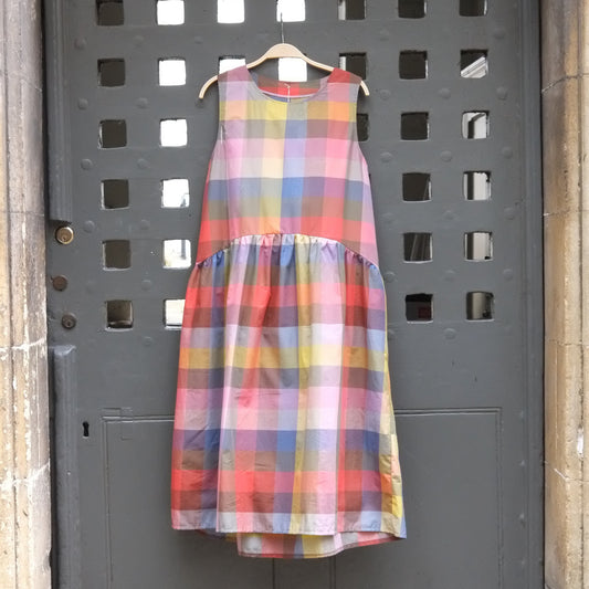 Rainbow check sleeveless dress hanging on grey door