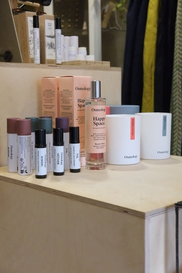Collection of skincare and cosmetic products on a wooden shelf.