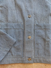 Load image into Gallery viewer, Close-up of a striped shirt with buttons on a wooden surface

